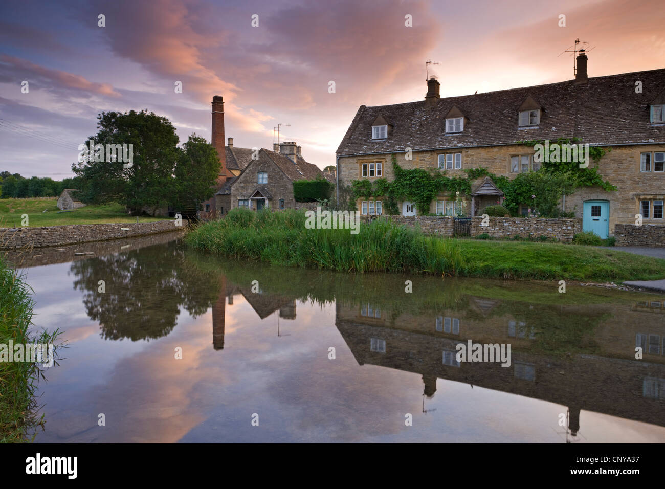 Cottages in the picturesque Cotswolds village of Lower Slaughter at sunrise, Gloucestershire, England. Summer 2011 Stock Photo
