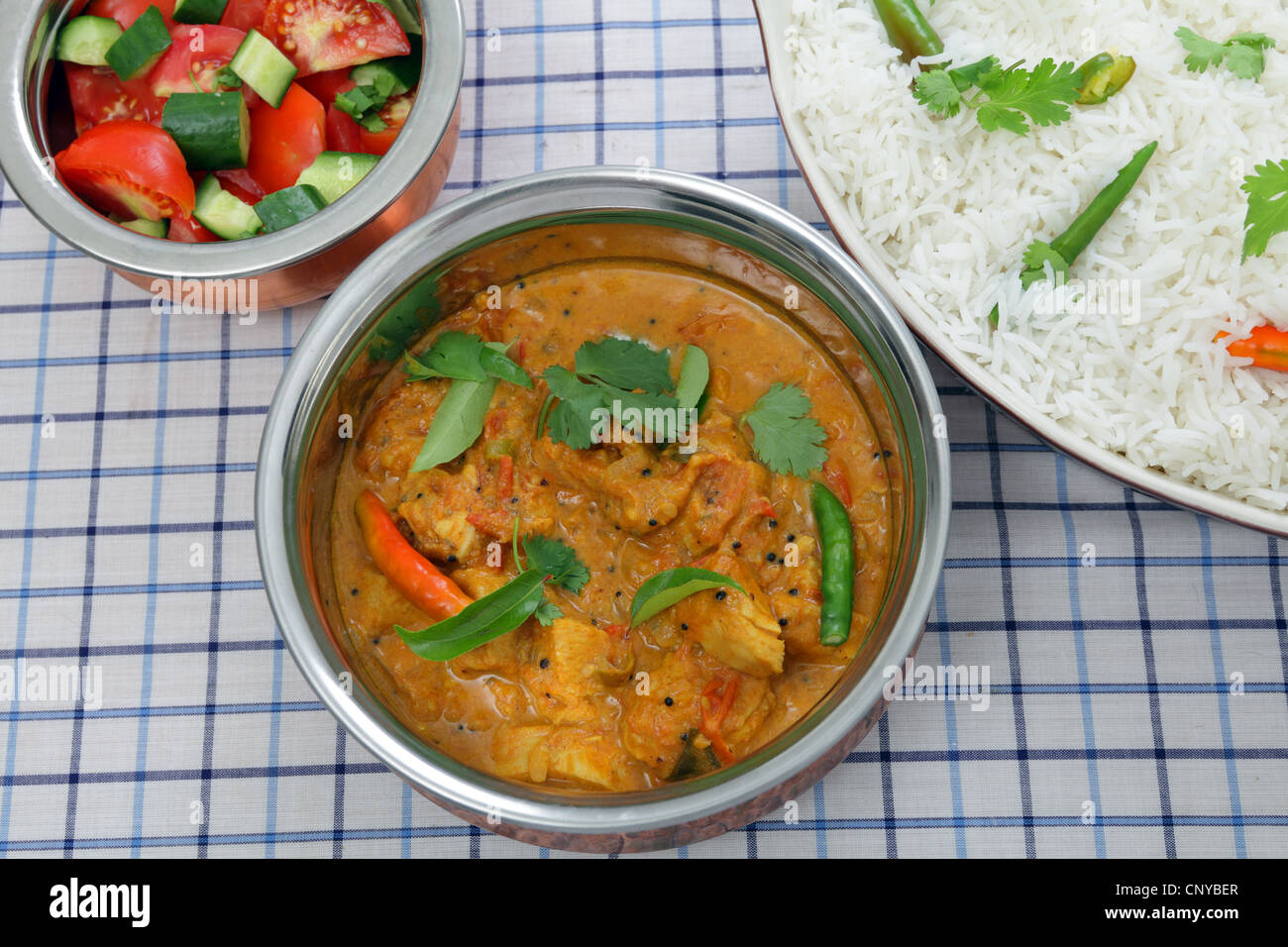 Serving a bowl of South Indian chicken, tomato and coconut milk curry