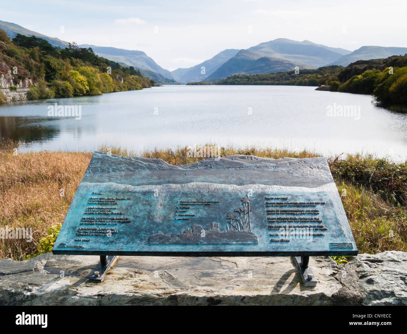 View along Llyn Padarn Lake to Mount Snowdon with plaque in foreground in Snowdonia. Brynrefail Llanberis Gwynedd North Wales UK Stock Photo