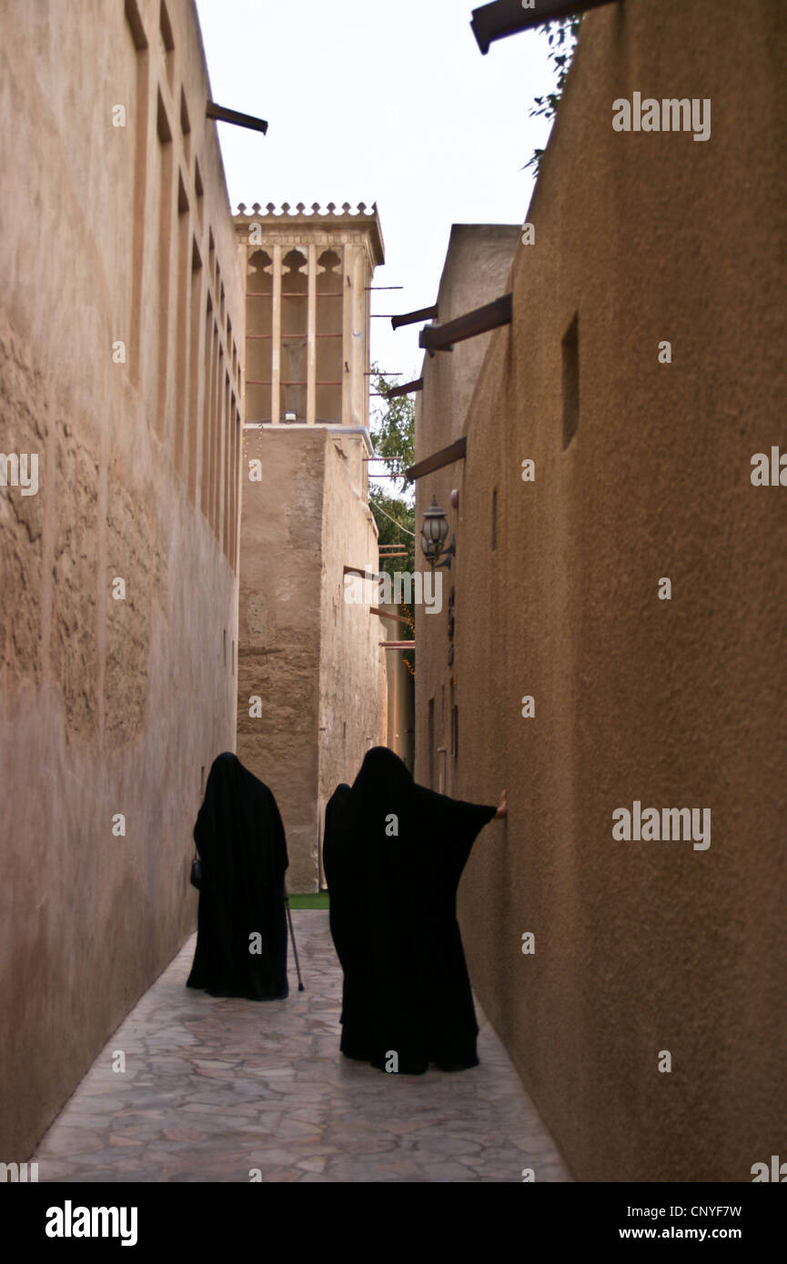 Two Arab women in traditional dress among the windtowers in Bastakiya, Dubai, United Arab Emirates Rear view. Stock Photo
