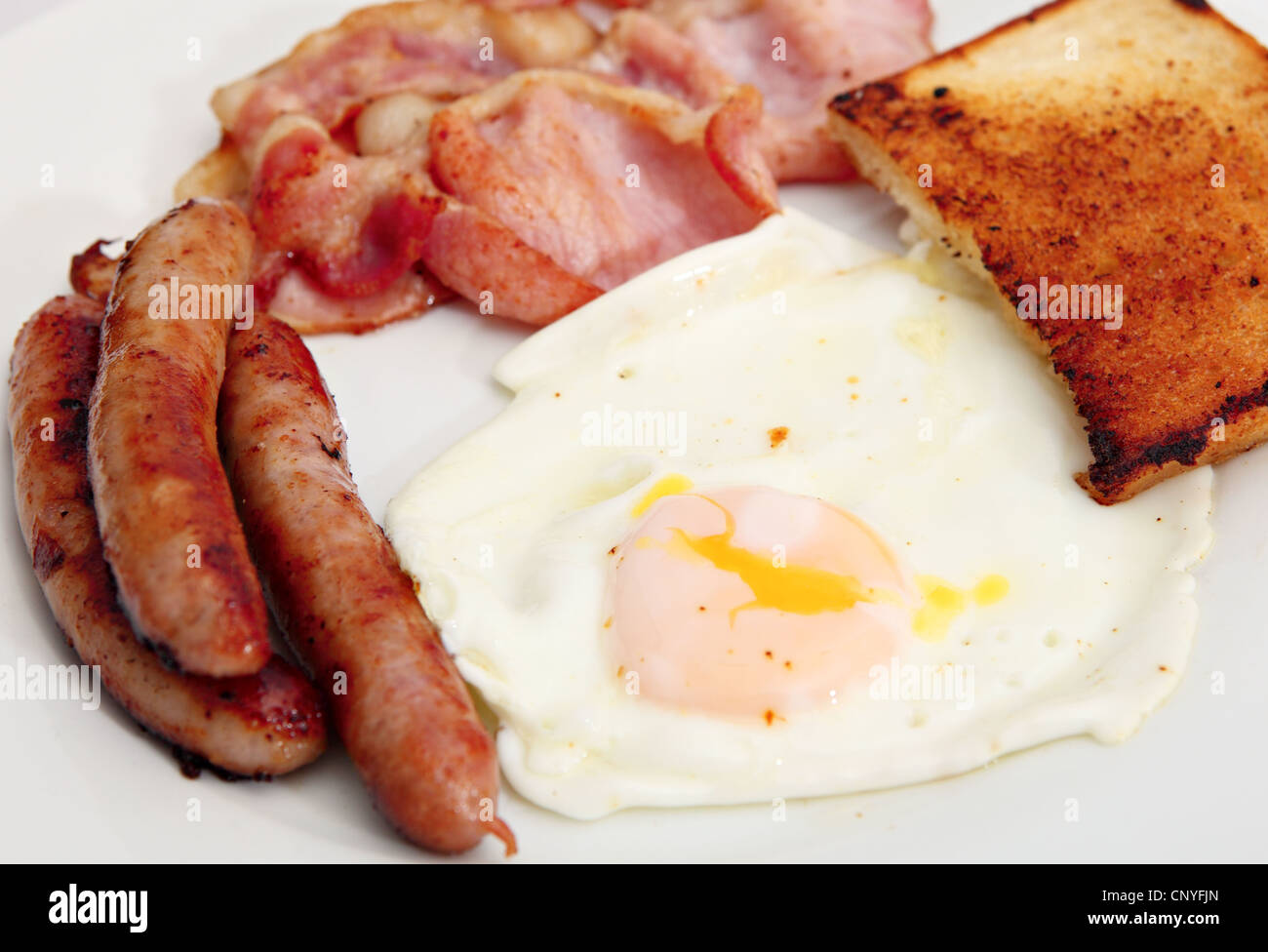 Traditional, unhealthy, English cooked breakfast of fried bacon, egg
