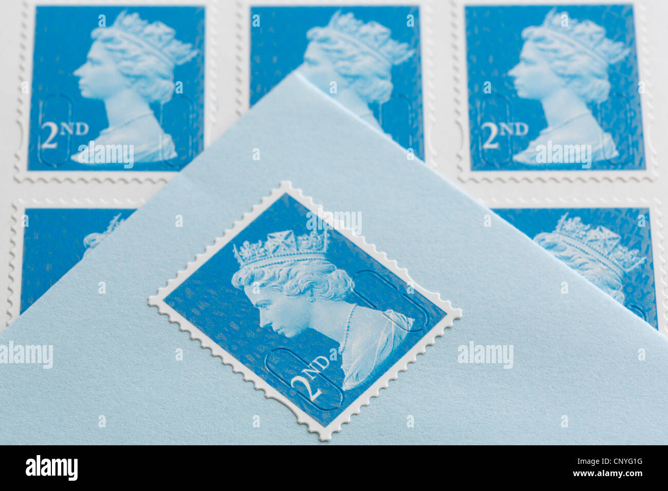 UK, Britain. Royal Mail second class postage stamps and an envelope with a stamp stuck on Stock Photo