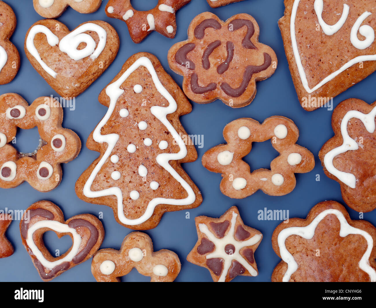 Decorative seasonal shapes of gingerbread cookies shot from above over dark blue background Stock Photo