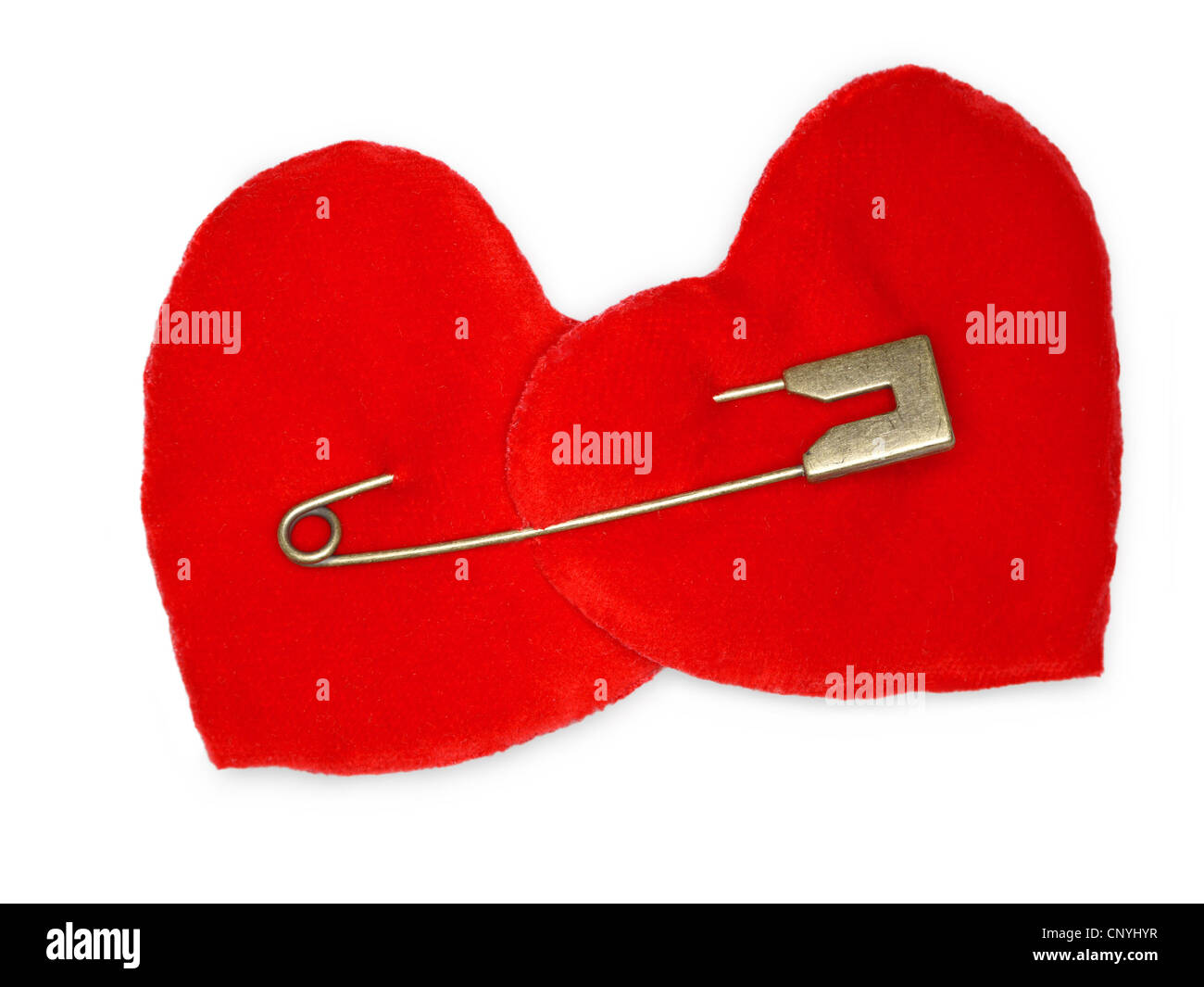 Two red suede hearts bonded with golden safety pin over white background Stock Photo