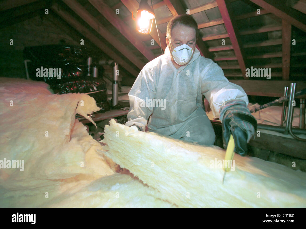 Insulating. Installing quilt loftinsulation to a roof space Stock