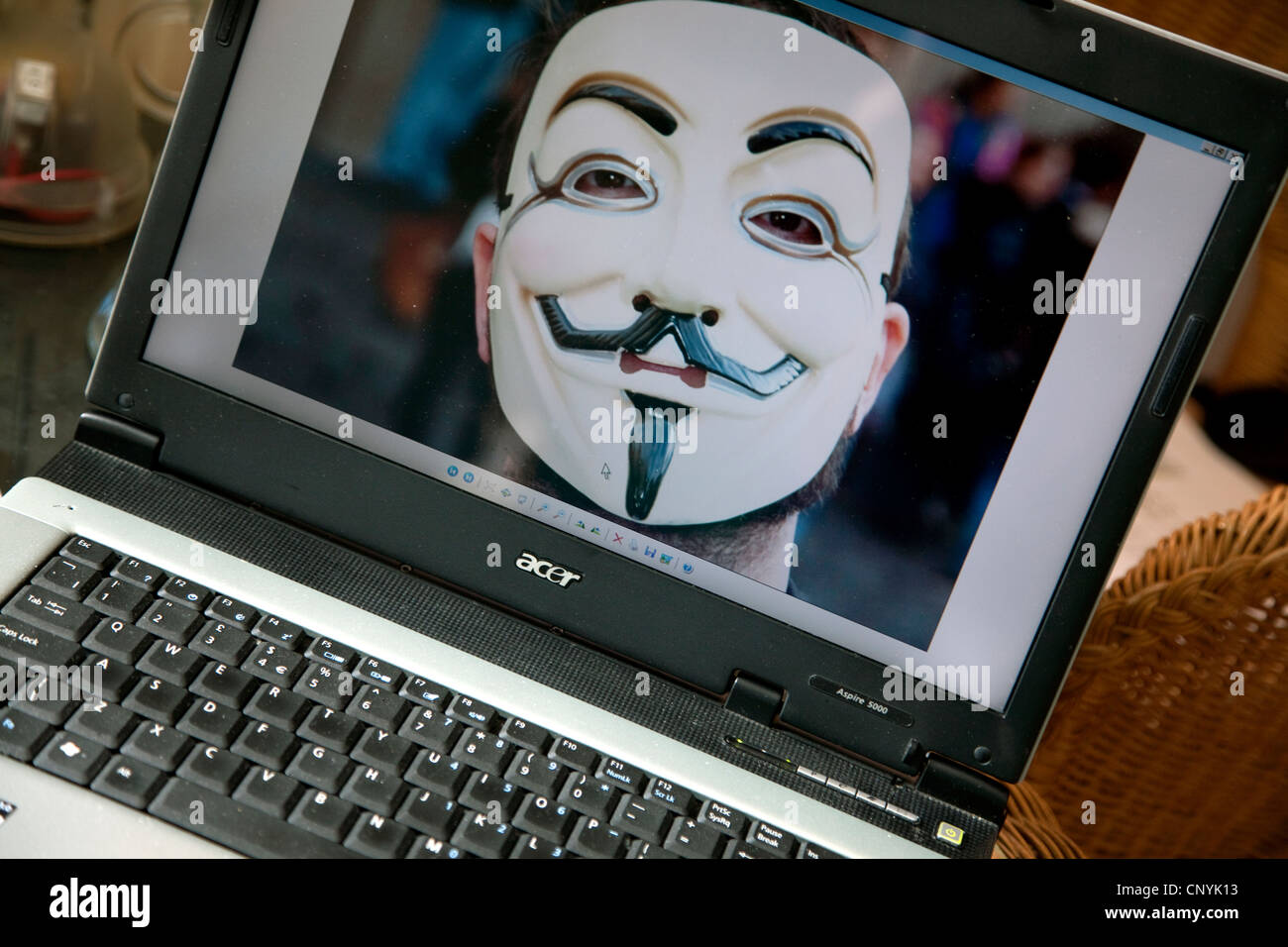 'Anonymous' masked face on computer screen, London Stock Photo