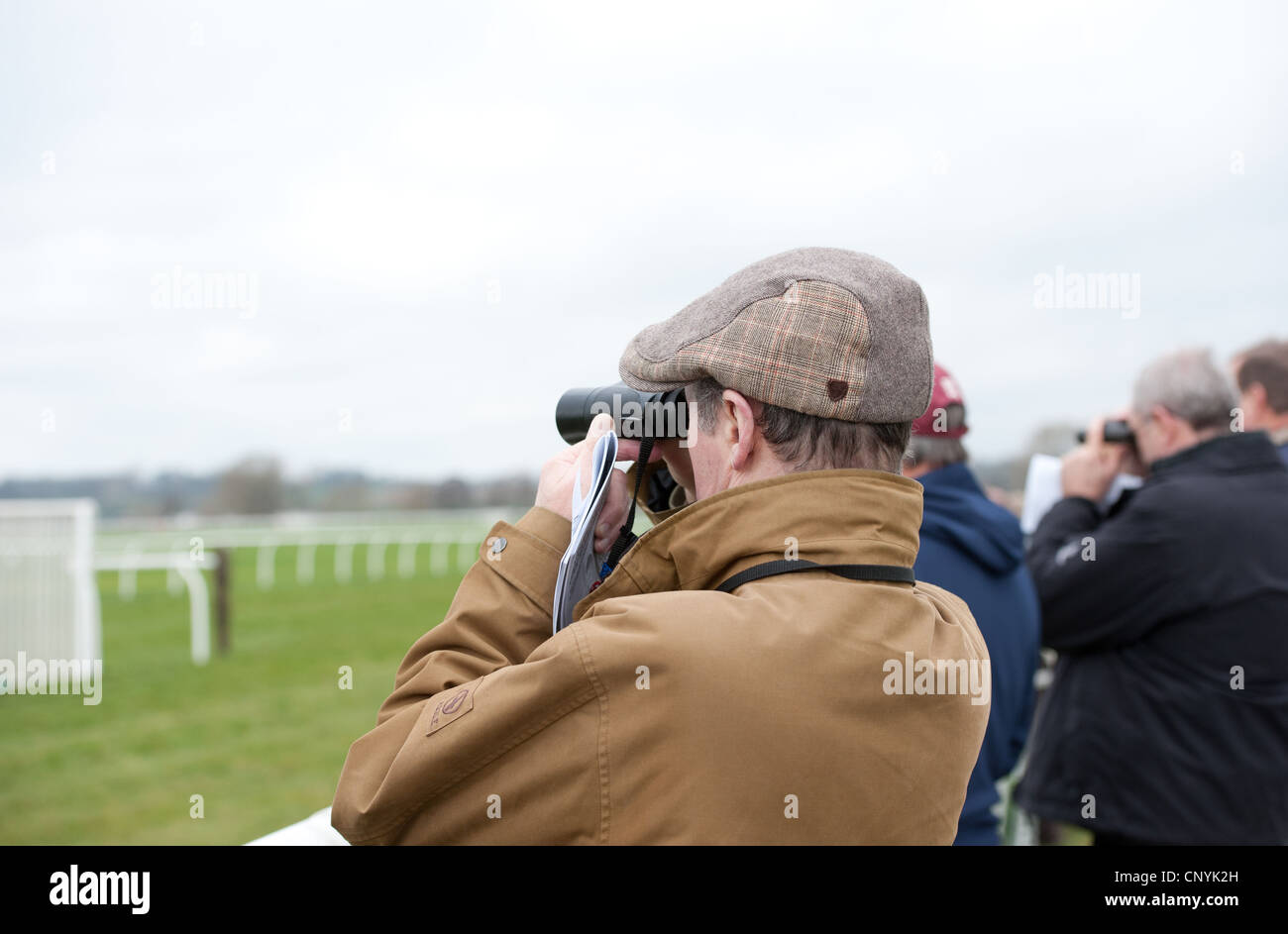 Watching a horse race through binoculars Stock Photo Alamy
