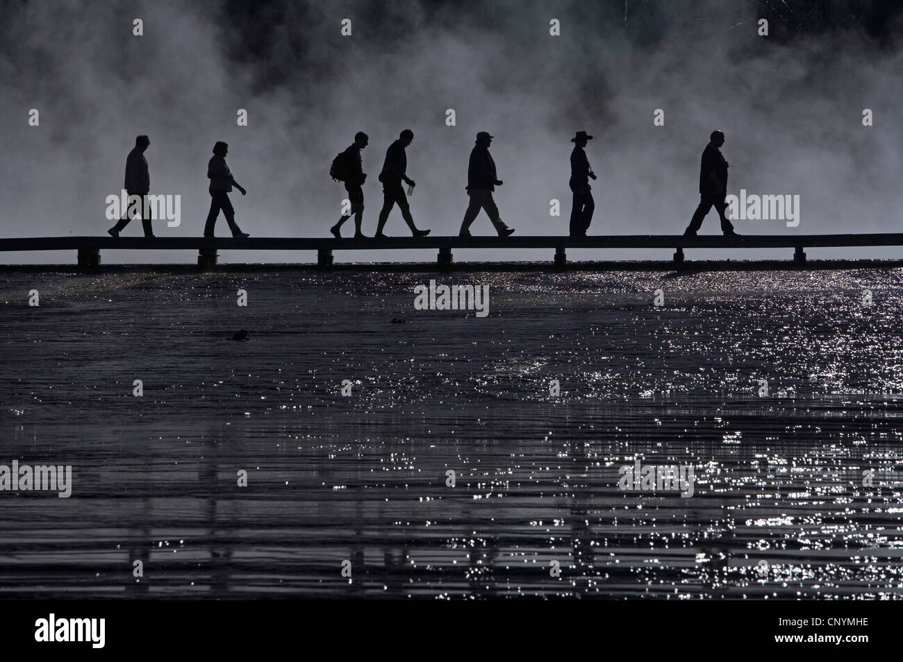 silhouettes of tourists on a boardwalk at Midway Geyser Basin, USA, Wyoming, Yellowstone National Park Stock Photo