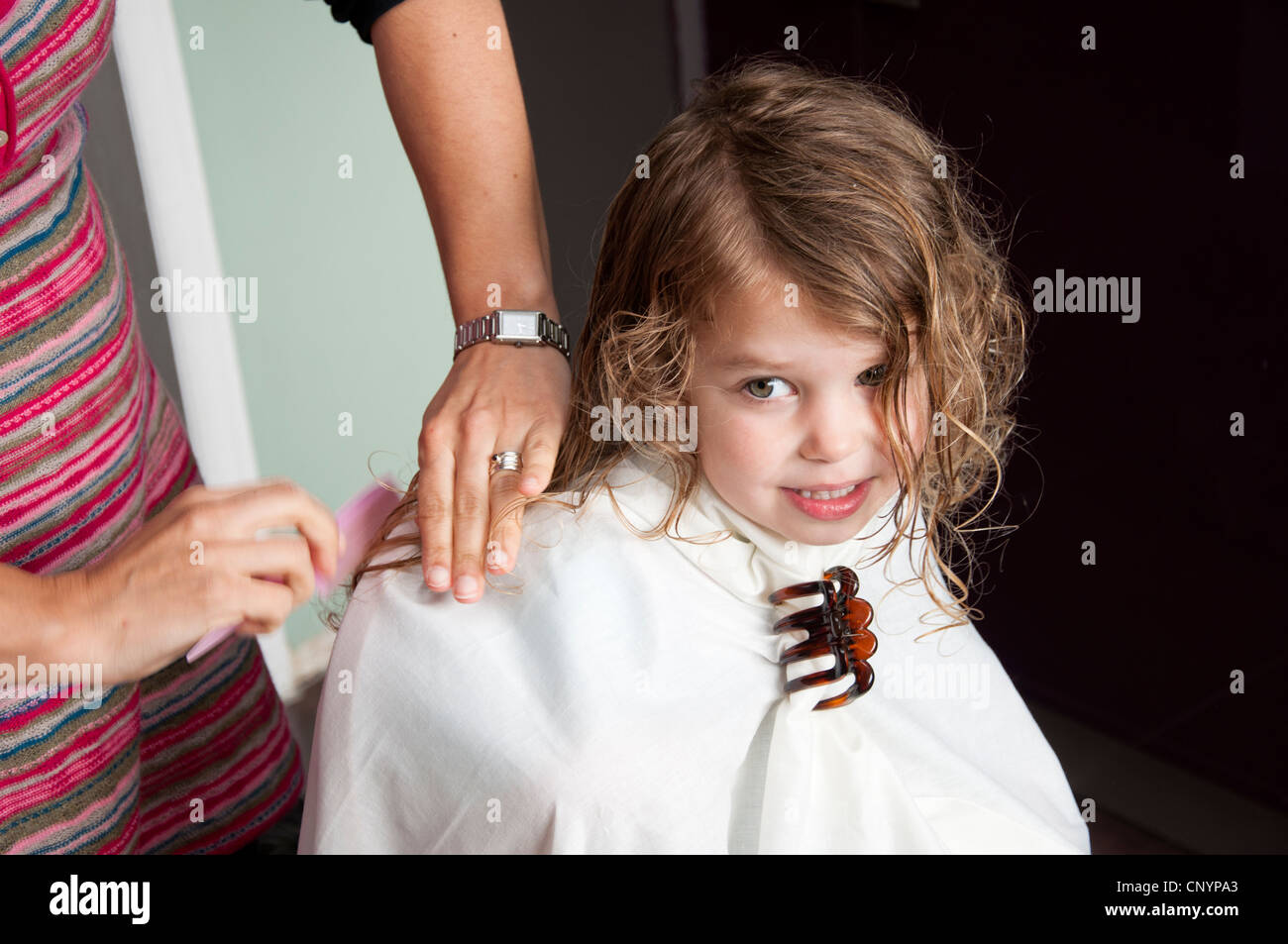 Mother cutting her three year old daughter's hair Stock Photo Alamy