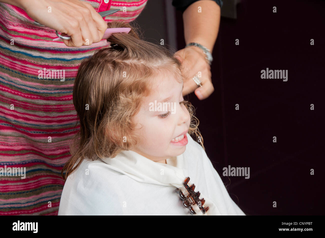 Mother cutting her three year old daughter's hair Stock Photo Alamy