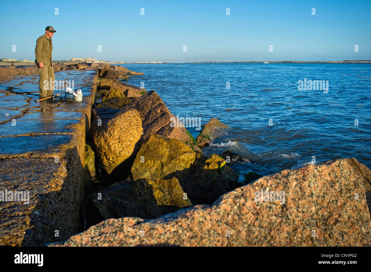 Man fishing off the jetties in Port Aransas at the Gulf of Mexico Stock Photo Alamy