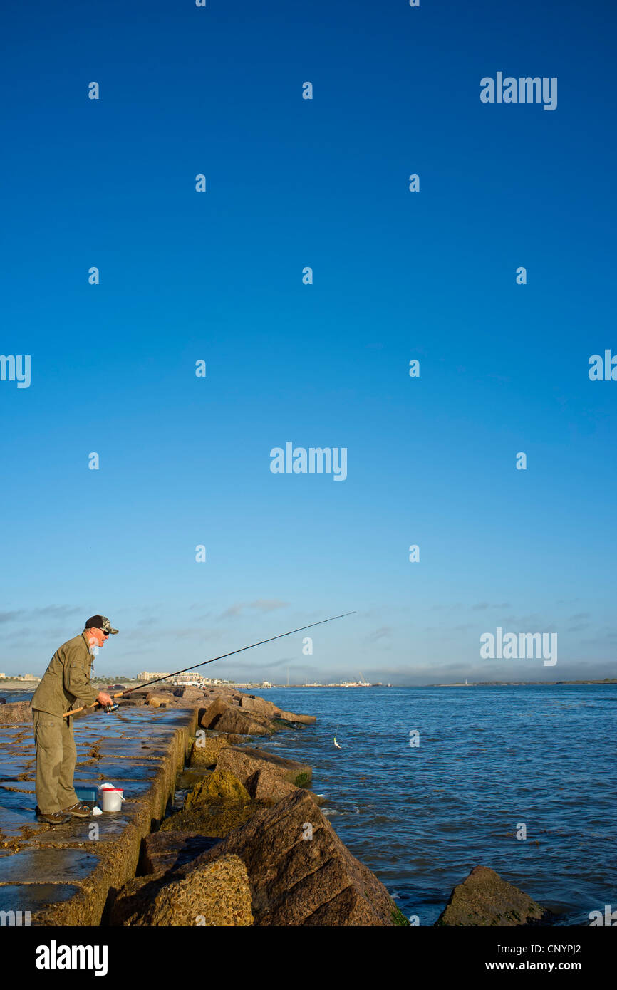 Man fishing off the jetties in Port Aransas at the Gulf of Mexico Stock Photo Alamy