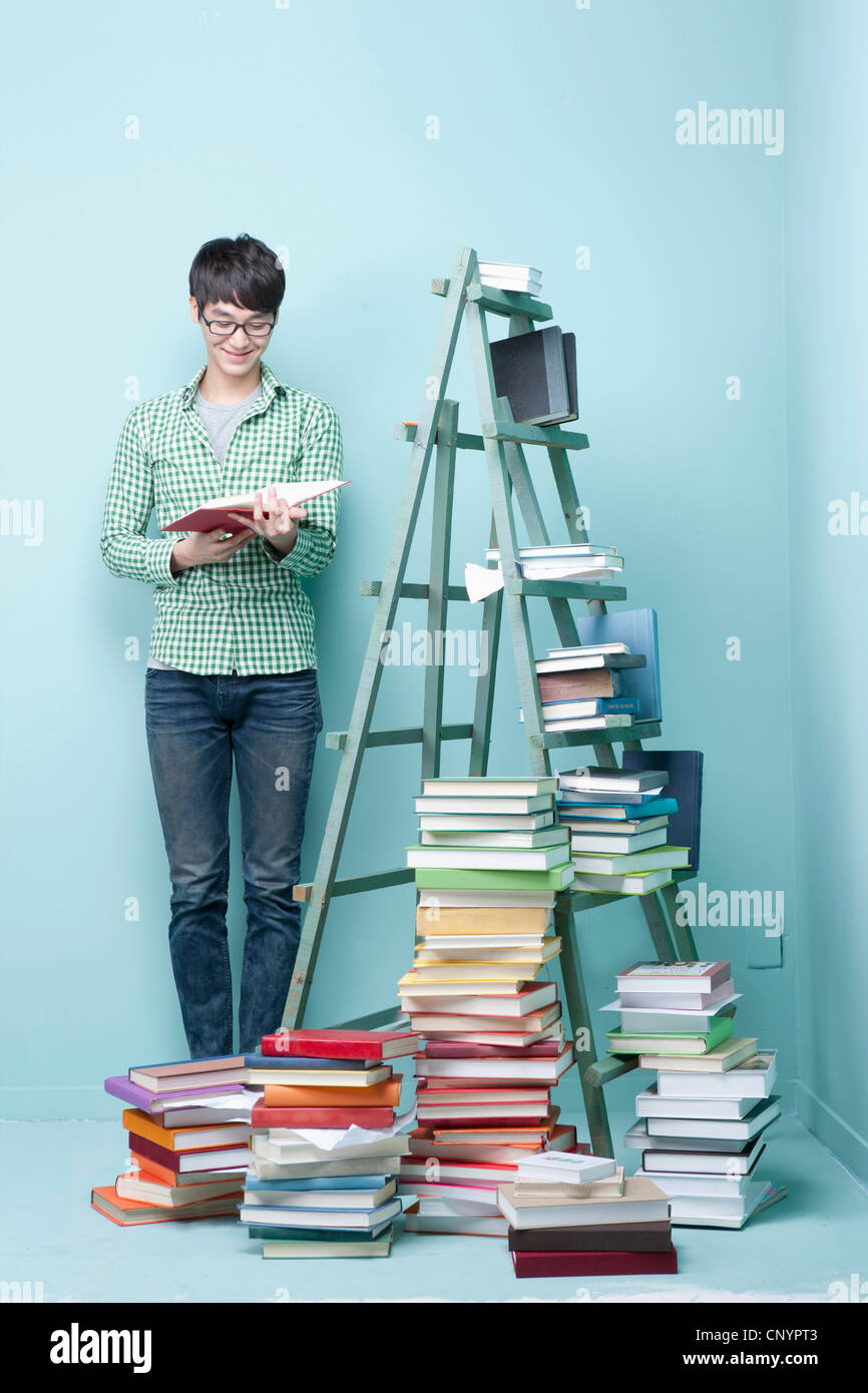 Study Man Stand A studying man by the piled books and ladder Stock Photo - Alamy