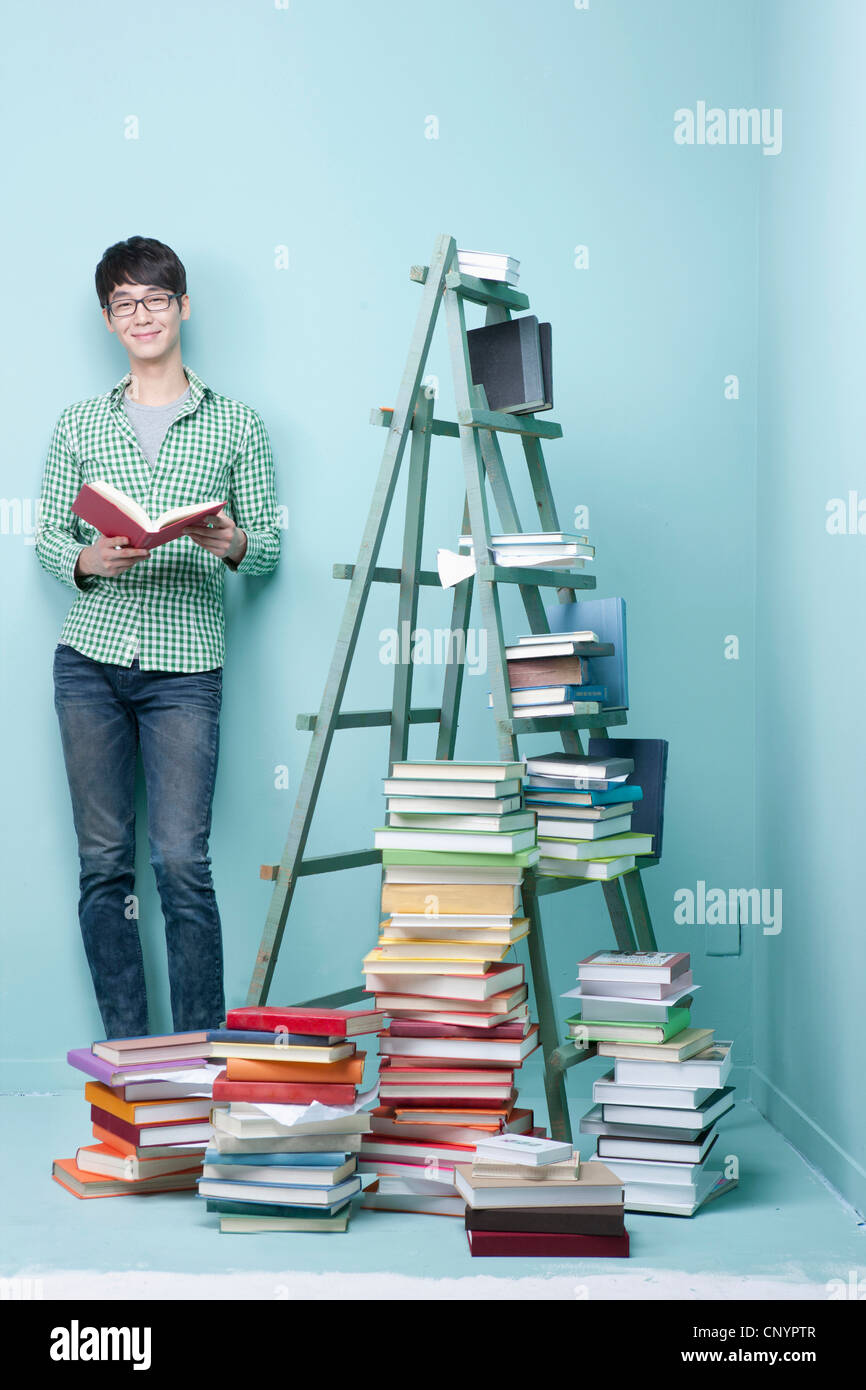 Study Man Stand A studying man by the piled books and ladder Stock Photo - Alamy