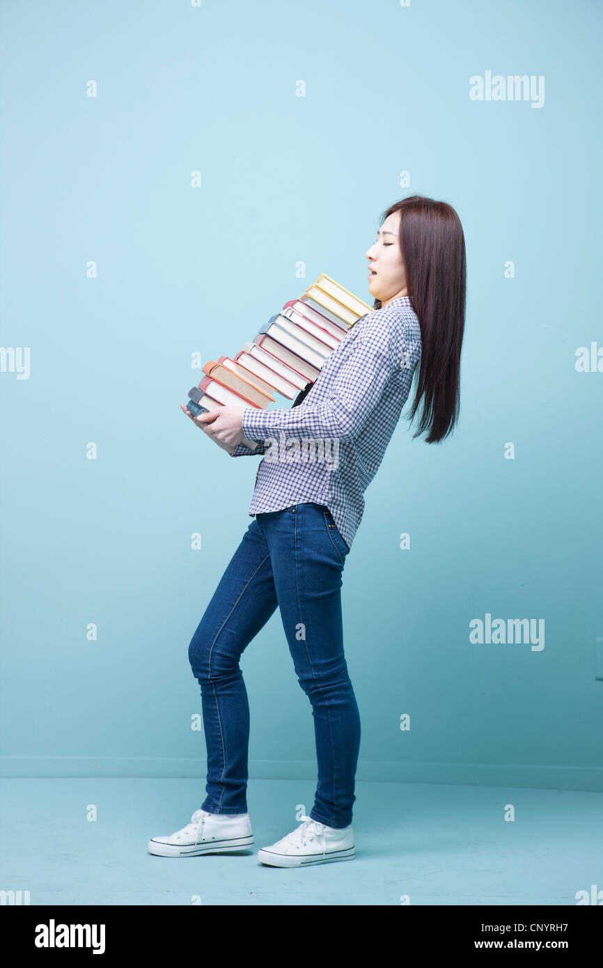 A woman carrying the pile of books Stock Photo - Alamy