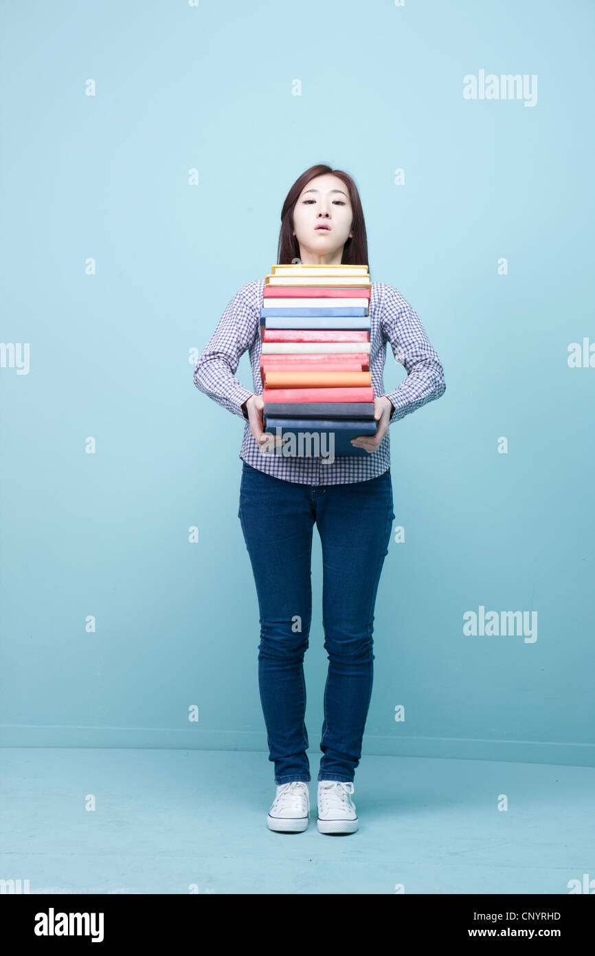 A woman carrying the pile of books Stock Photo - Alamy