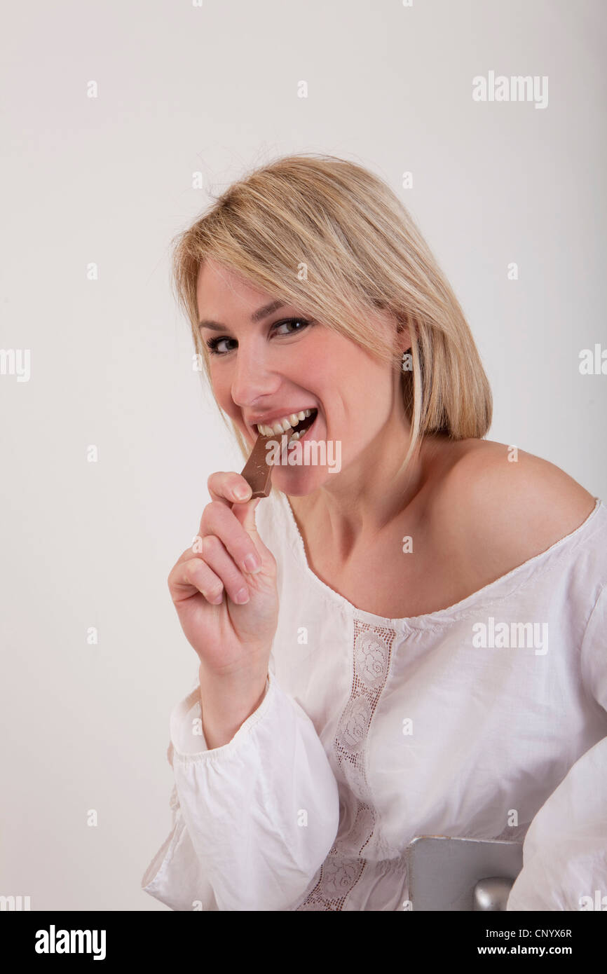 woman eating a bar of chocolate Stock Photo