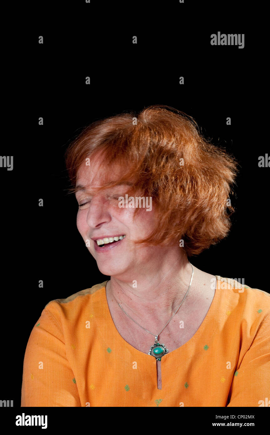 Motion blur of middle aged woman waiving her head in blissful abandon and singing to herself