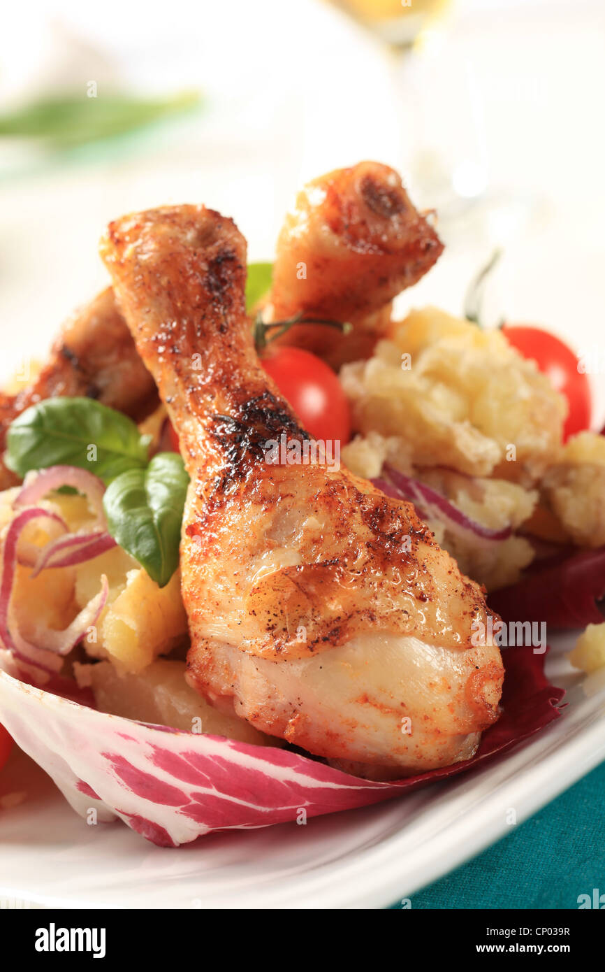 Roasted chicken drumsticks with crushed potatoes and lettuce Stock