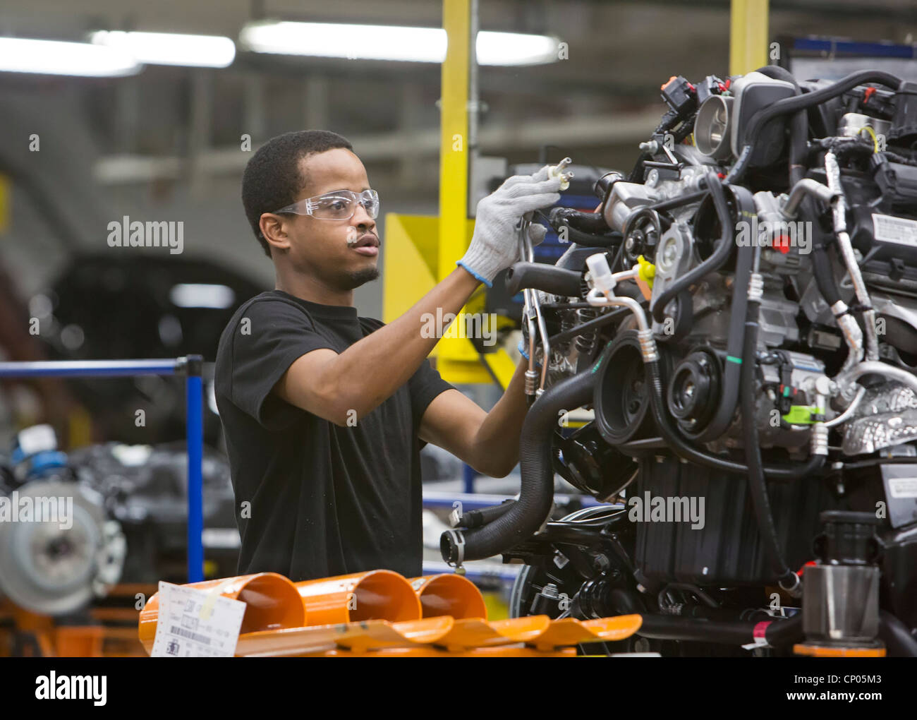 Detroit, Michigan A worker adds parts to an engine at Chrysler's