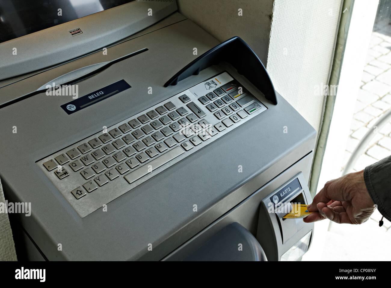 Placing a card into a German Automat bank terminal that issues statements, Rosenheim Upper Bavaria Germany Stock Photo