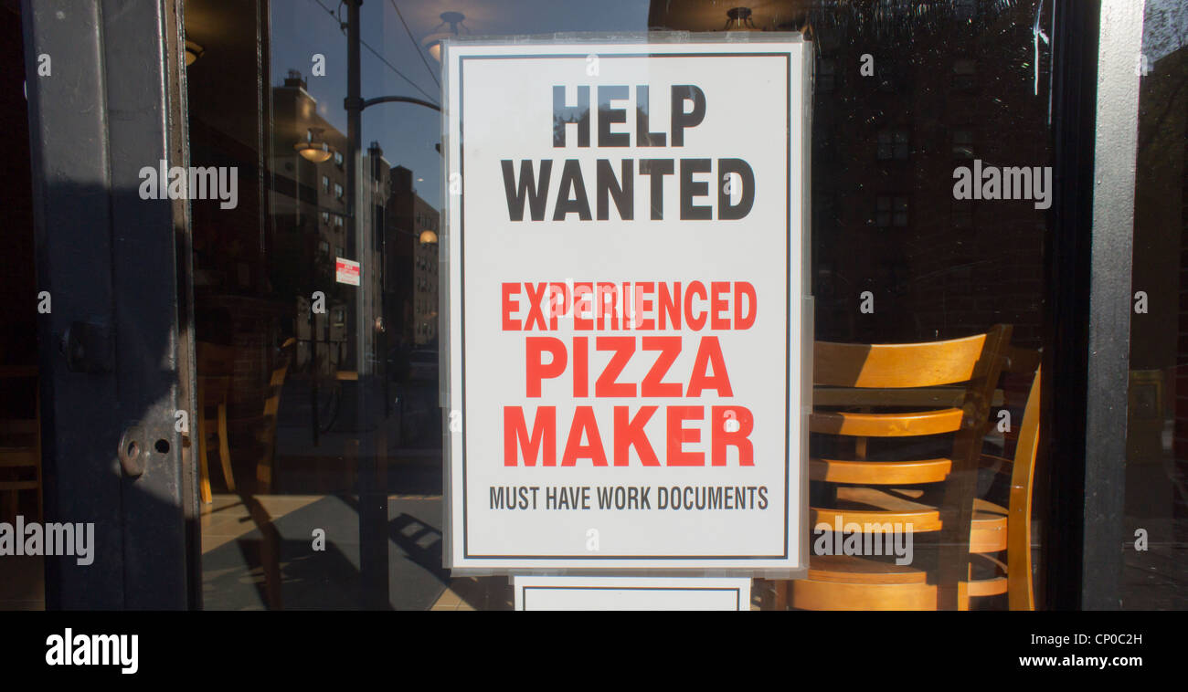 A sign advertising for an experienced pizza maker is seen in the window of a pizzeria in the Chelsea neighborhood of New York Stock Photo