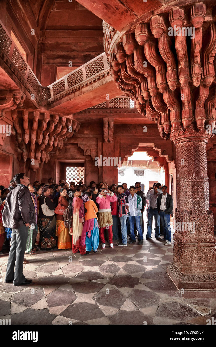 Fatehpur Sikri, Uttar Pradesh, India. Indian tourists Viewing the Throne Pillar in the Diwan-i-Khas (Hall of Private Audience). Stock Photo