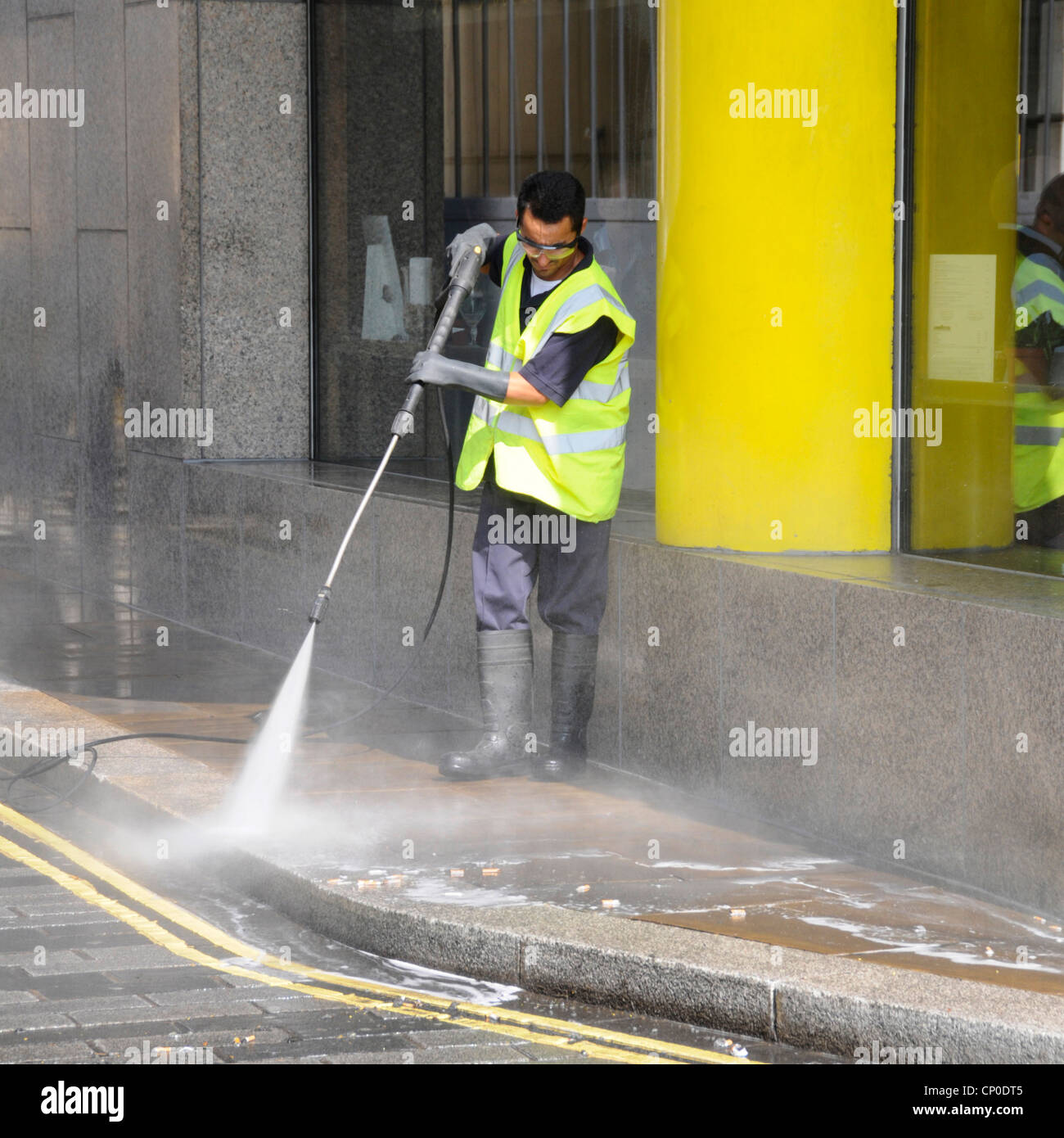 Street scene man working in high vis jacket & wearing gloves goggles