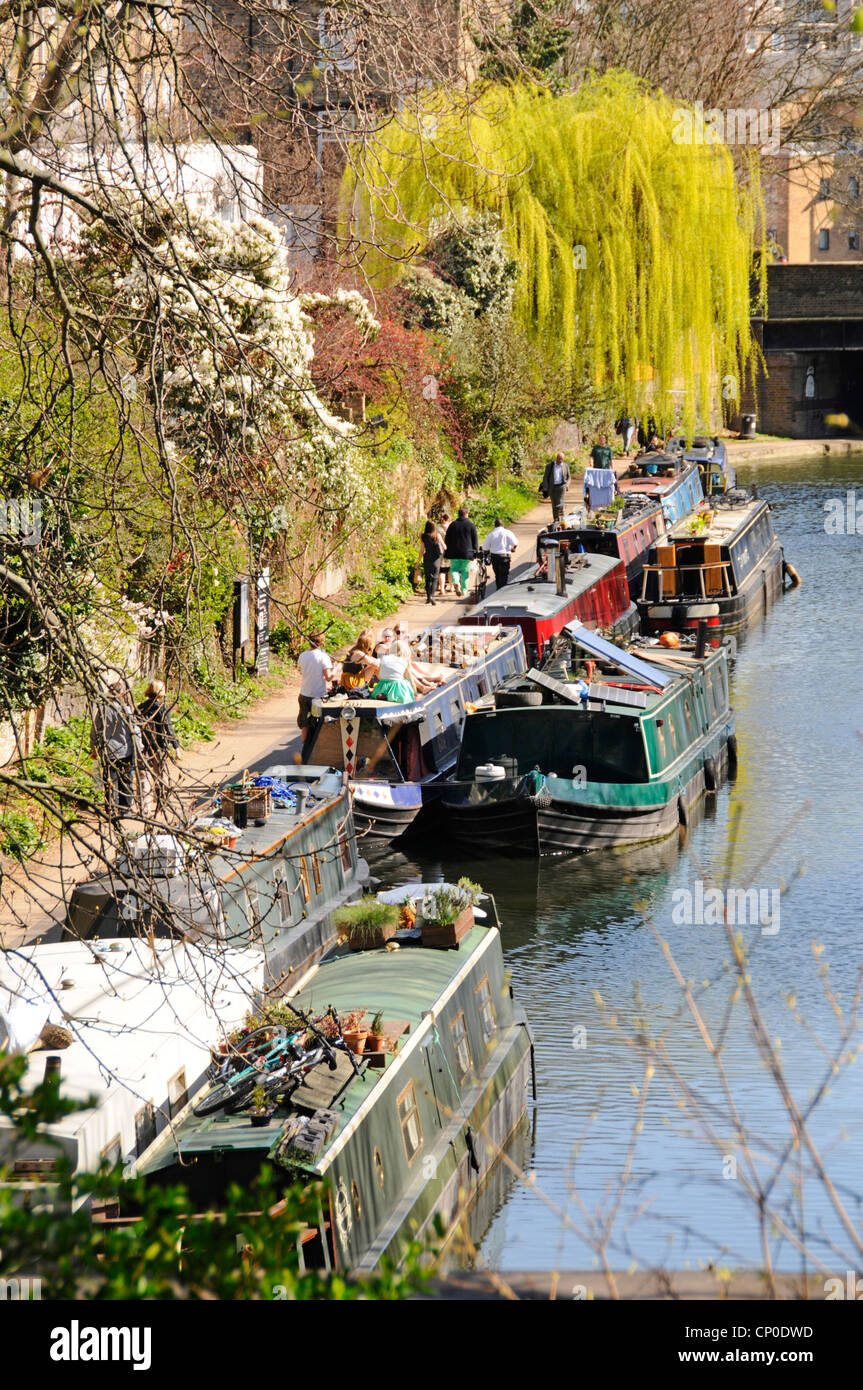 Aerial view Regents Canal narrowboat moorings & people walking along towpath with spring colours on Weeping Willow tree Islington London England UK Stock Photo