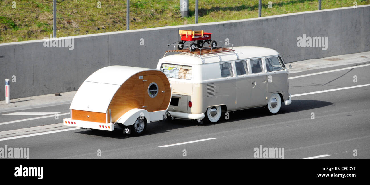 Unusual VW RV campervan motorhome with roof rack towing Teardrop Micro trailer type camper caravan along M25 motorway Essex England UK Stock Photo