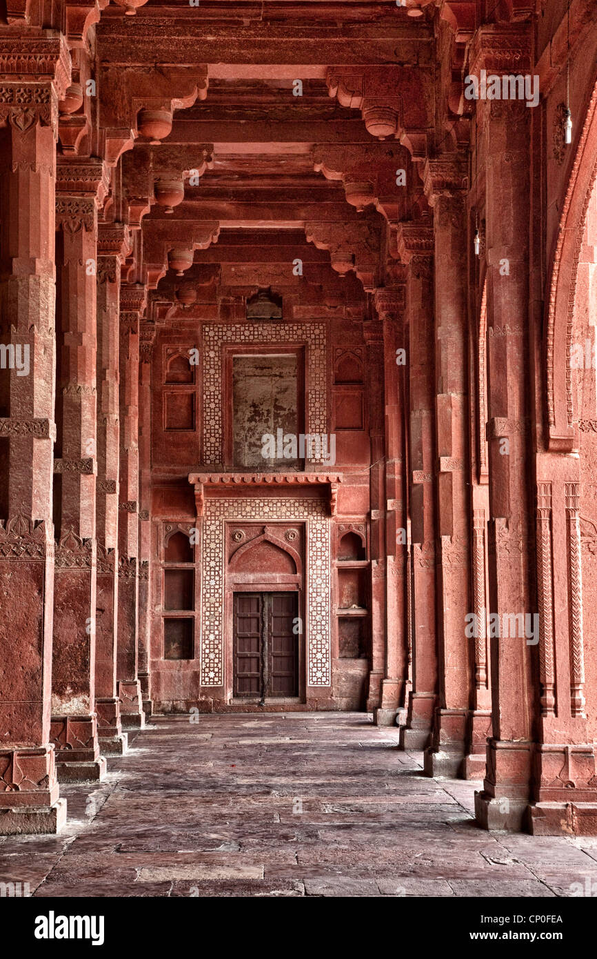 Fatehpur Sikri, India. Corridor of the Jama Masjid (Dargah Mosque). Hindu-style arches overhead, Islamic arch over the door. Stock Photo