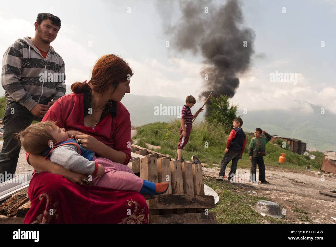 A Roma woman breastfeed her baby while waits for authorities to displace them to new house that authorities made for Stock Photo