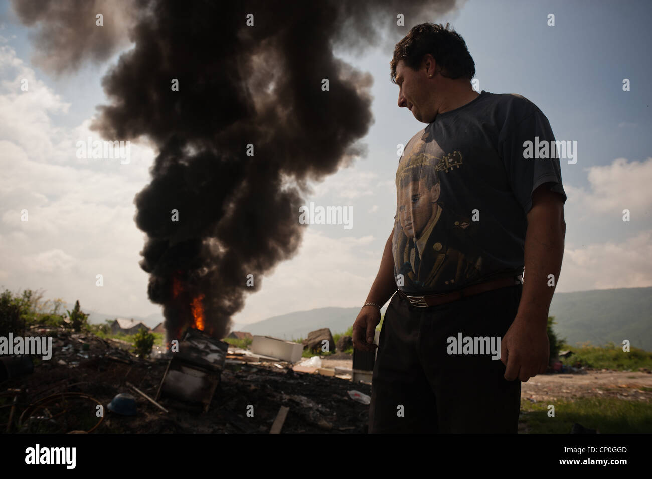 Roma man watch fire while waits for authorities to displace them to new house that authorities made for Roma people Stock Photo