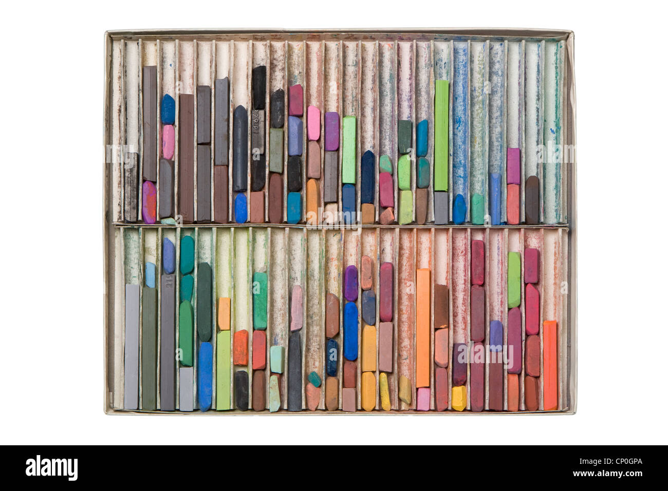 Top down view of large box of used, messy colored artist pastel chalks lying in vertical rows. Stock Photo
