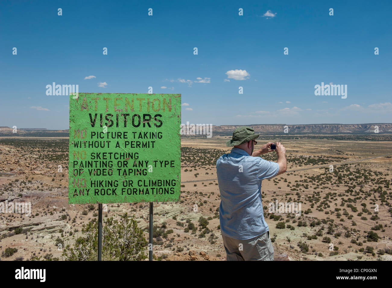 Photographer taking a photograph beside a no photography sign. Acoma Sky City in New Mexico. USA Stock Photo