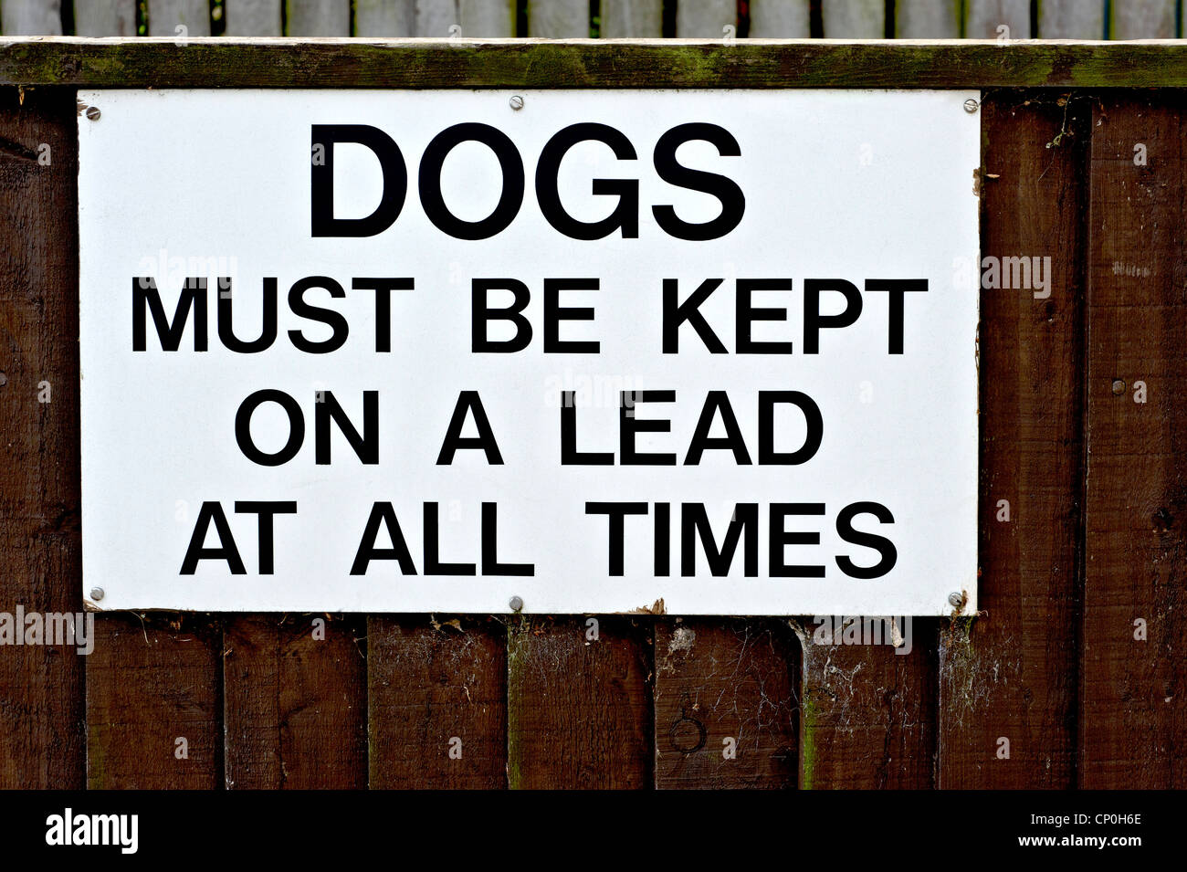 sign on a fence warning that dogs must be kept on a lead Stock Photo