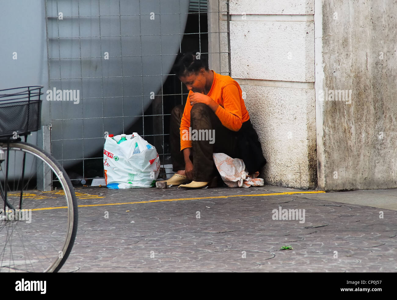 An African woman immigrant  begging on a railway station of Padua. Stock Photo