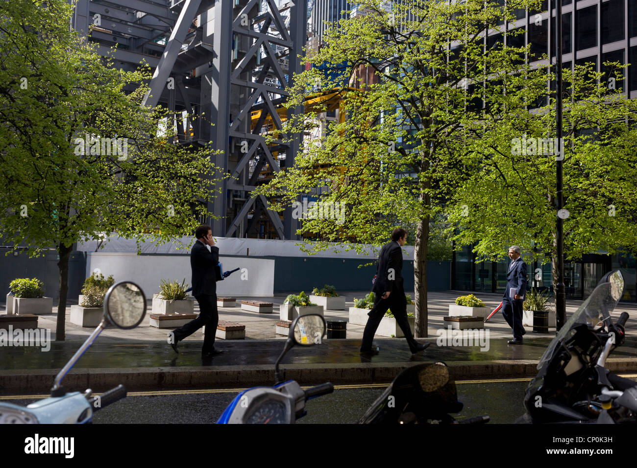 City workers walk past the giant Pinnacle office building construction development in the City of London. Stock Photo