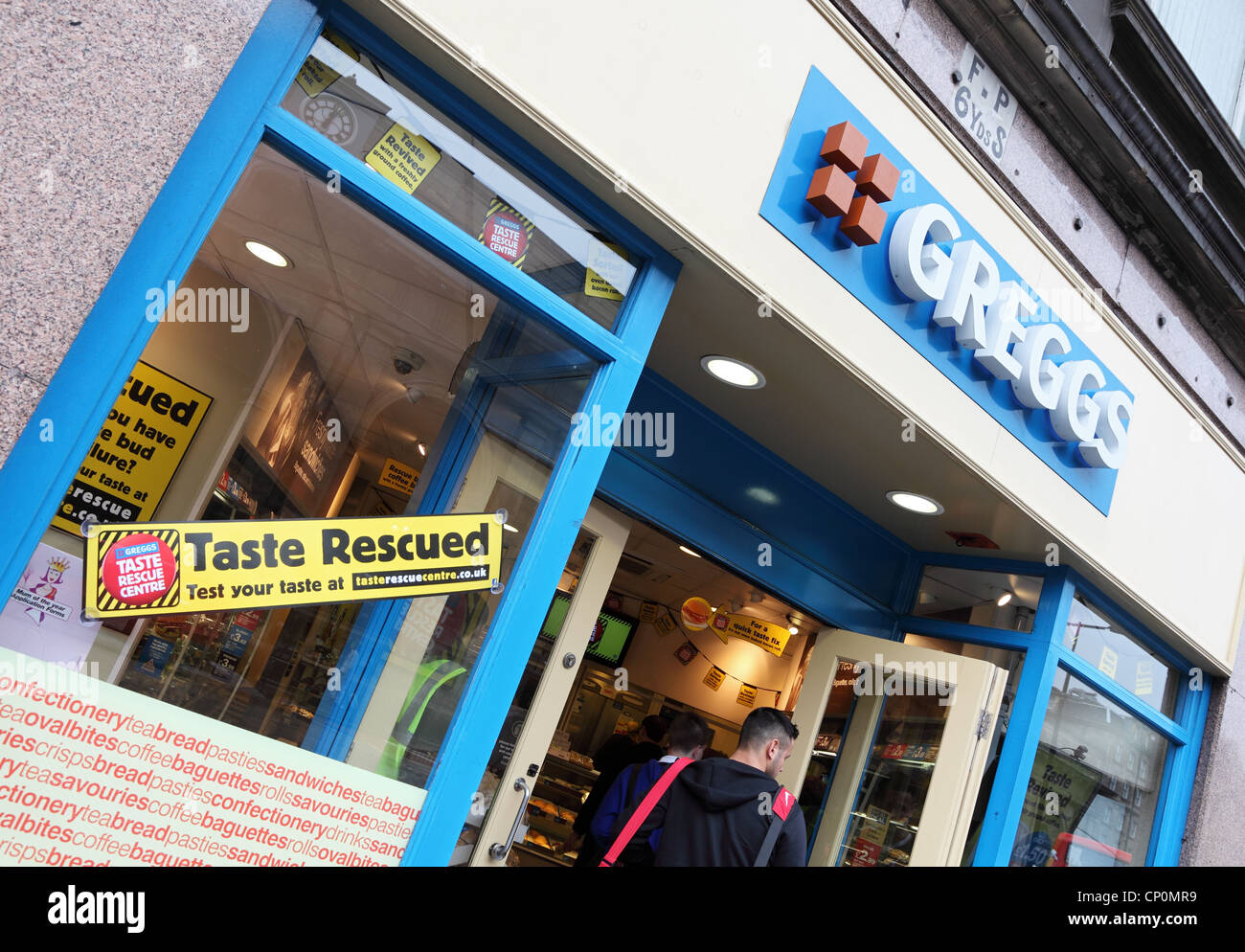 Young man entering Greggs the bakers shop in Newcastle upon Tyne, England, UK Stock Photo