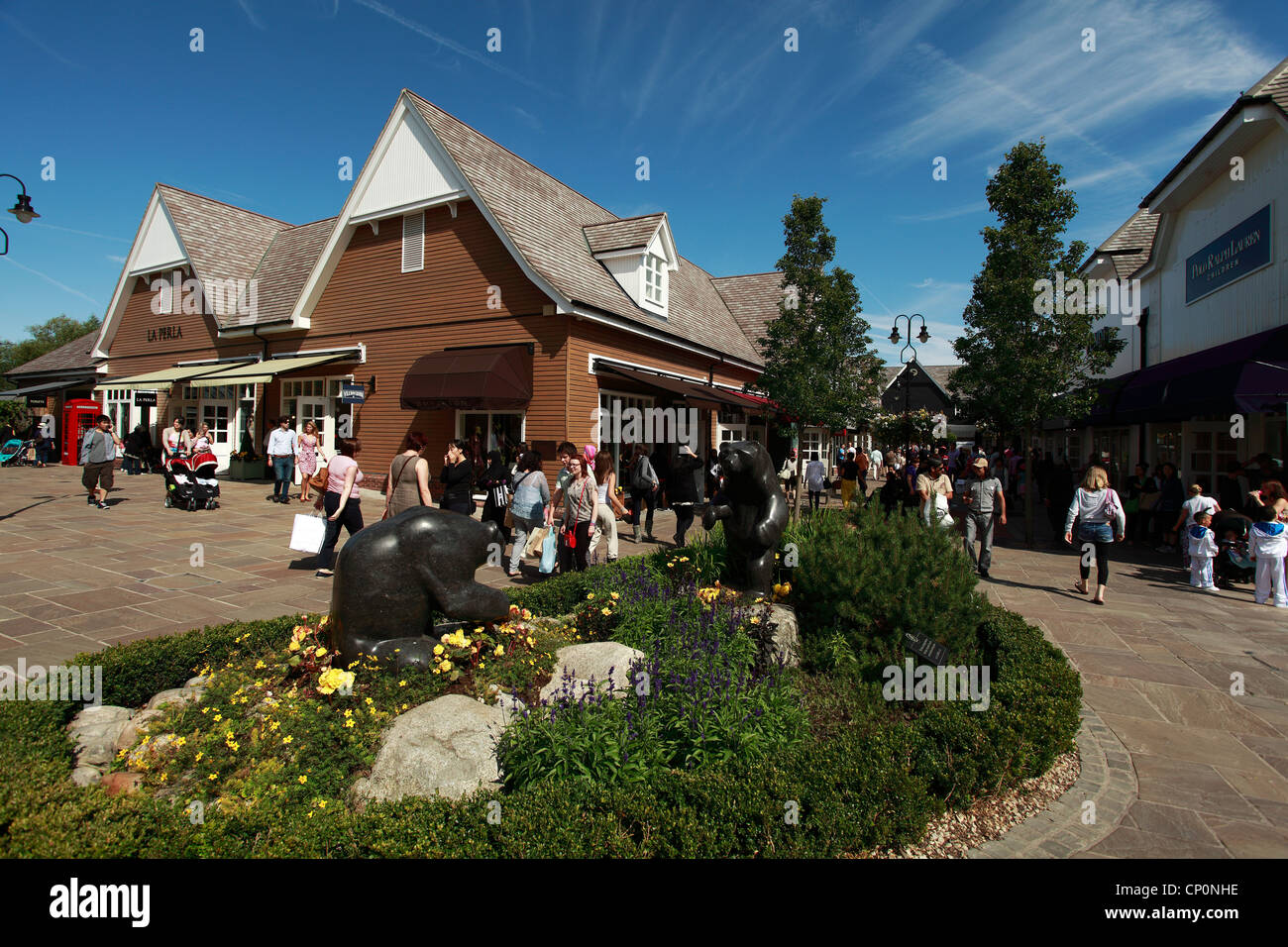 Granite Bears and Shoppers at Bicester Shopping Outlet, Oxfordshire, UK Stock Photo