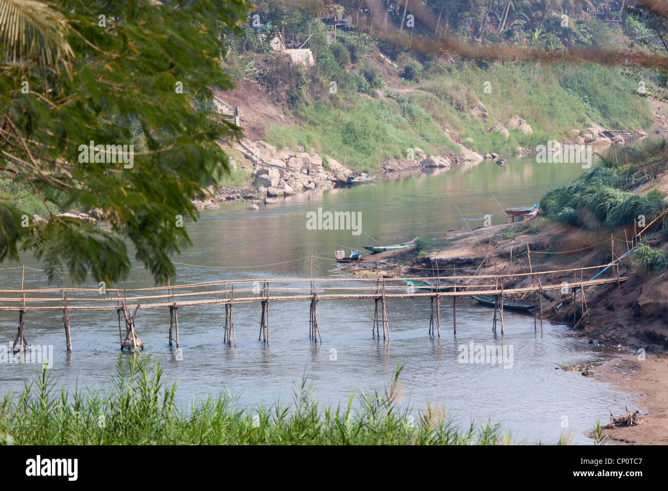 A flimsy bamboo footbridge thrown across the Khan river, a tributary of the Mekong (Luang Prabang - Laos). Passerelle en bambous Stock Photo