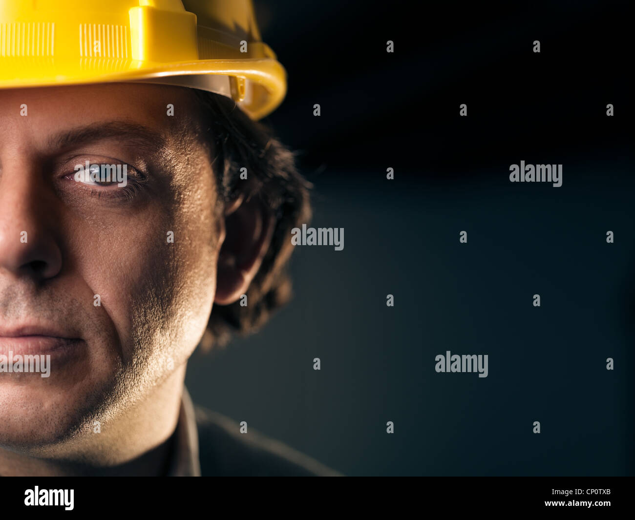 Portrait of serious middle aged man working as construction worker with hardhat. Copy space Stock Photo