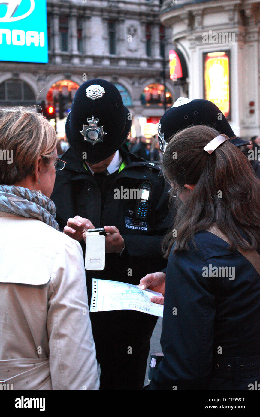 Policemen helping tourist find their way Stock Photo