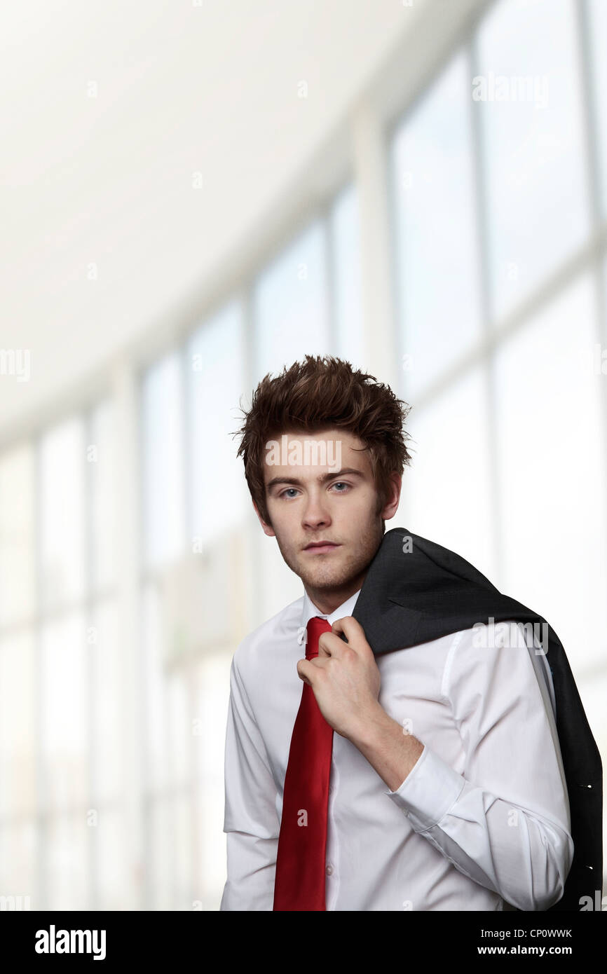 young casual looking businessman with his jacket off and over the