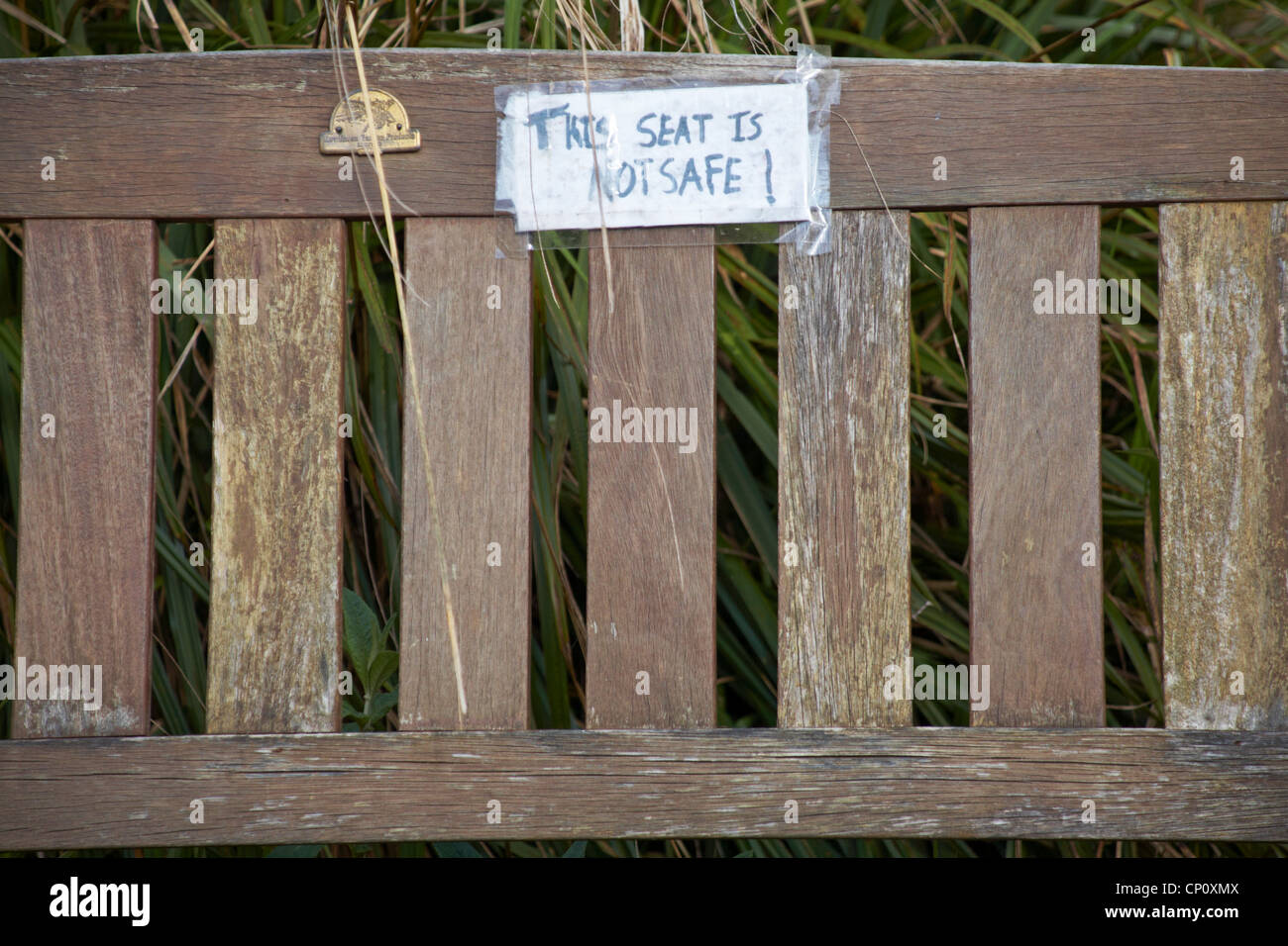 This seat is not safe notice on back of bench in UK Stock Photo - Alamy