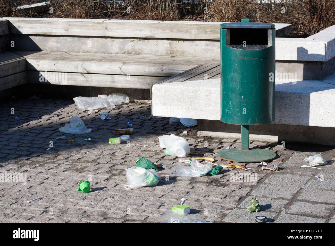 littered area with empty trashcan Stock Photo