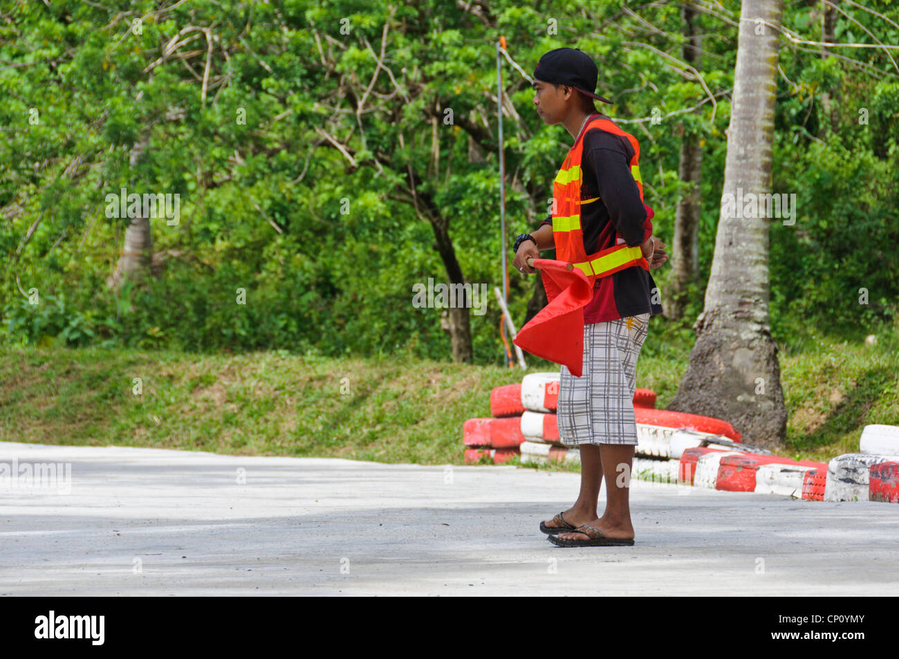 Asian Track Marshal with red flag - Adventure Park Puerto Galera Oriental Mindoro Philippines Southeast Asia Stock Photo