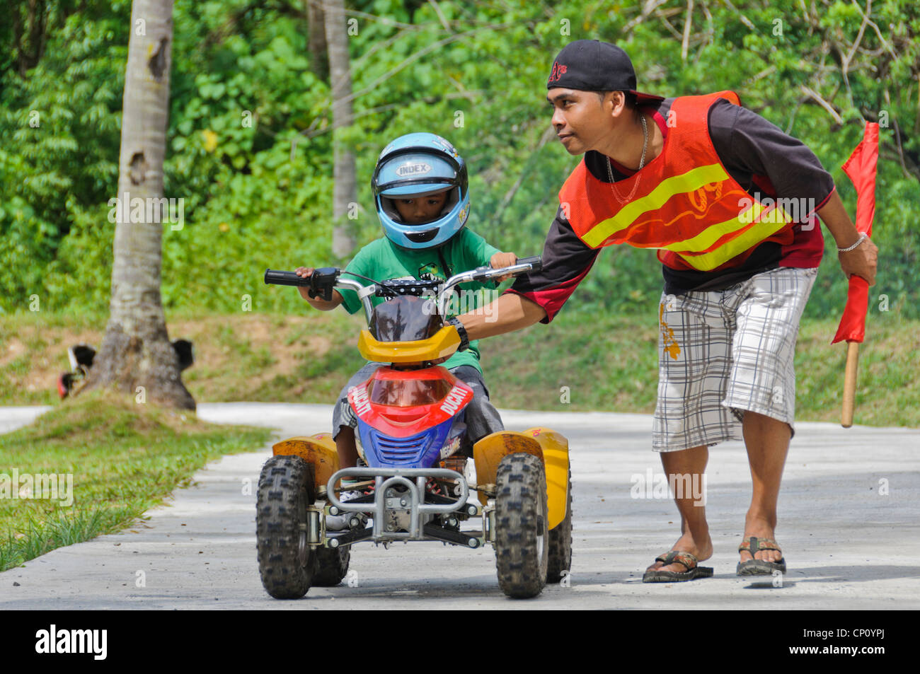 Little Asian boy with big helmet riding 