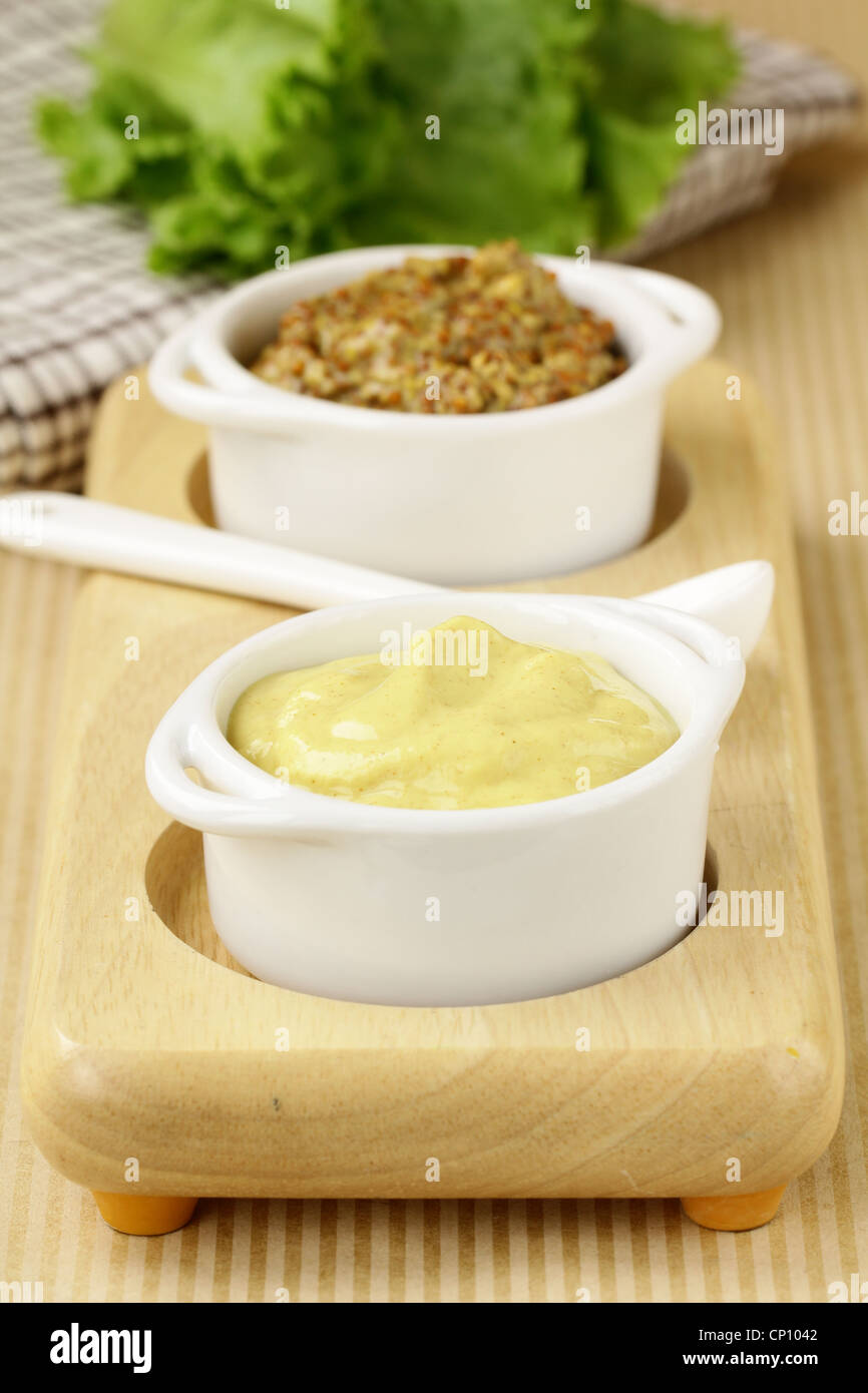 French mustard sauce in white gravy boat Stock Photo