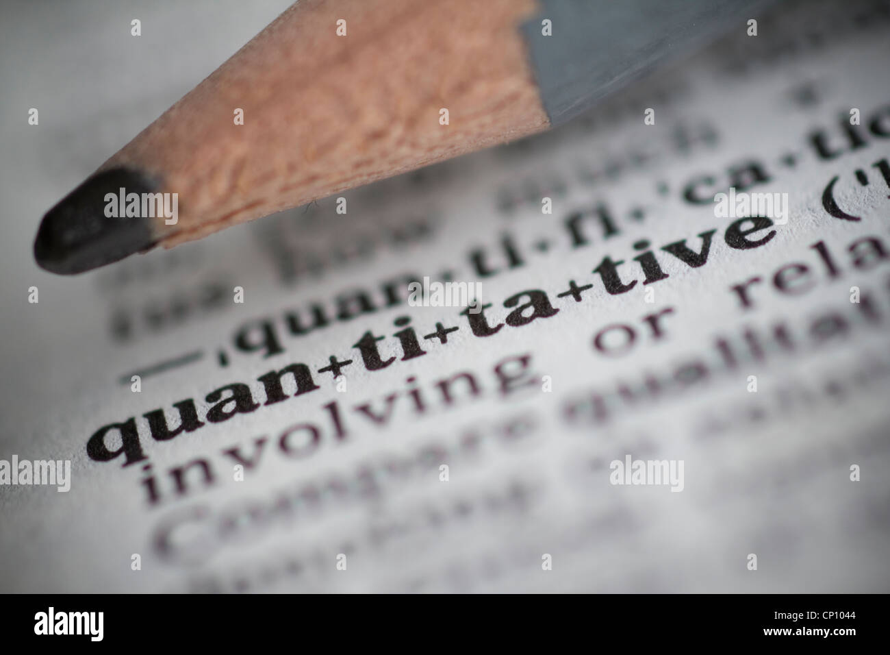 the word quantitative in dictionary to illustrate quantitative easing with pencil Stock Photo